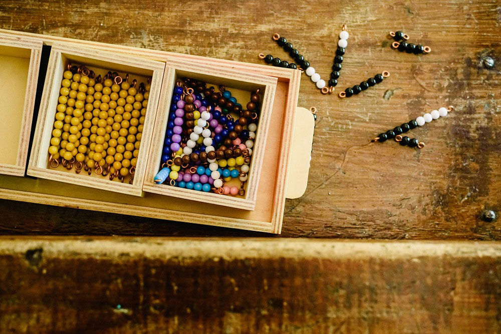A child working with Montessori math materials on the floor